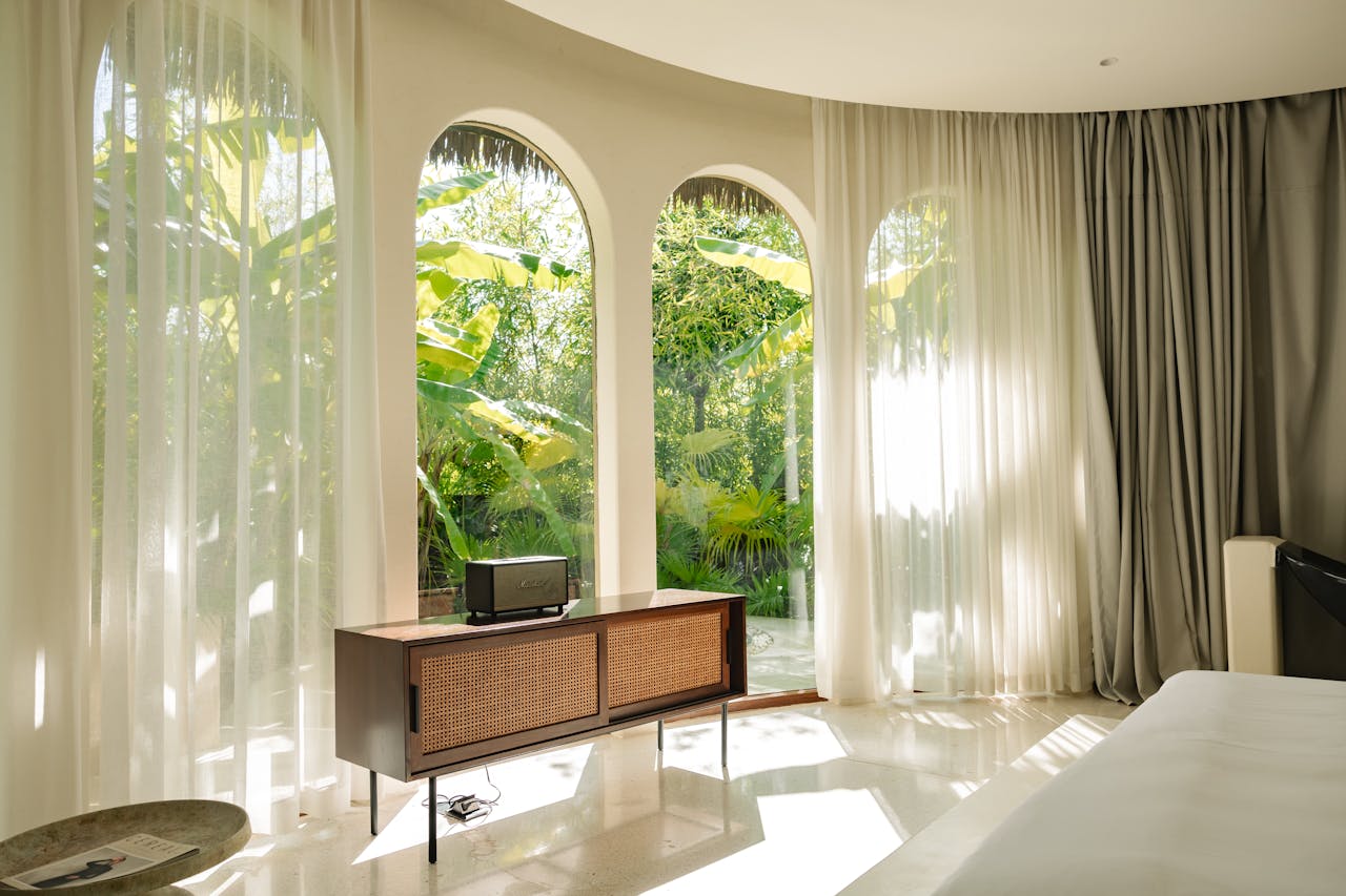 Luxurious room with garden view, featuring sunlight and minimalist decor.